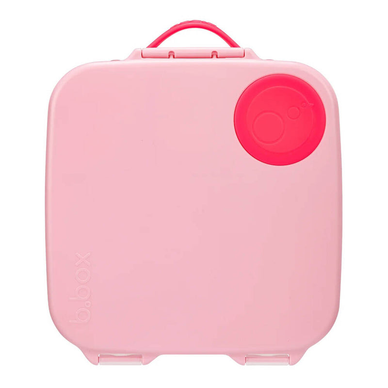 The b.box B.Box Lunchbox Flamingo Fizz is a square, light pink kids’ lunchbox with rounded edges, a red circle in the top right, an embossed "b.box" logo at the lower left, and a pink handle on top.