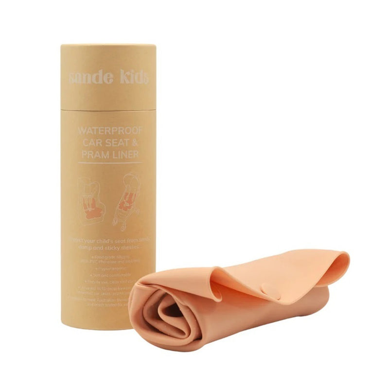 A rolled-up coral pink Sande Kids Waterproof Car Seat & Pram Liner sits in front of its cylindrical cardboard container labeled “Sande Kids Waterproof Car Seat & Pram Liner” on a white background.