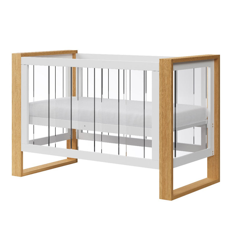 The Babyhood Kaylula Bella Cot by Babyhood features clear acrylic panels, a white frame, and light wood corner accents. This modern crib includes a white mattress and can be paired with a toddler conversion kit for extended use.