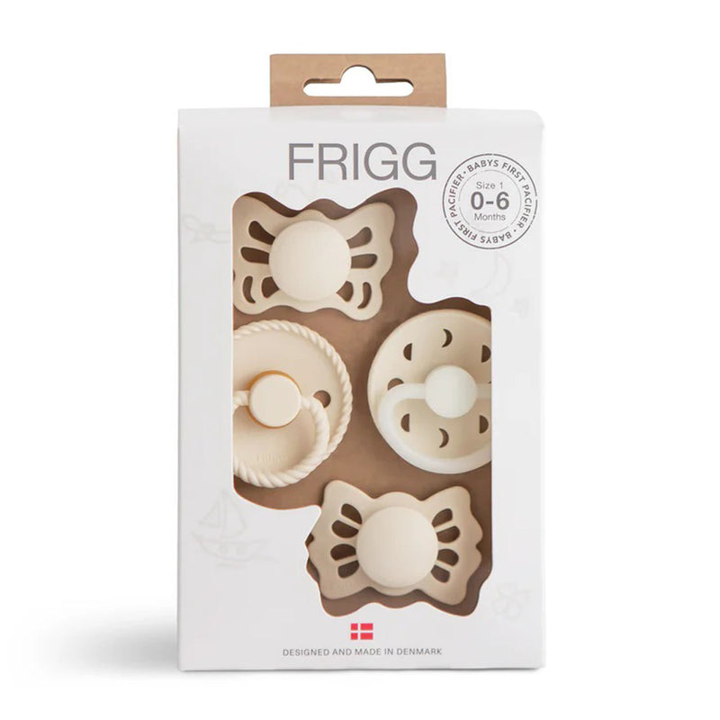 The Frigg 1st Dummies Set in Cream includes three pacifiers—Butterfly, Rope, and Moon Phase Night Lucky—for babies 0-6 months. Shown in white packaging with a window, these essentials feature natural rubber nipples and unique cream designs.
