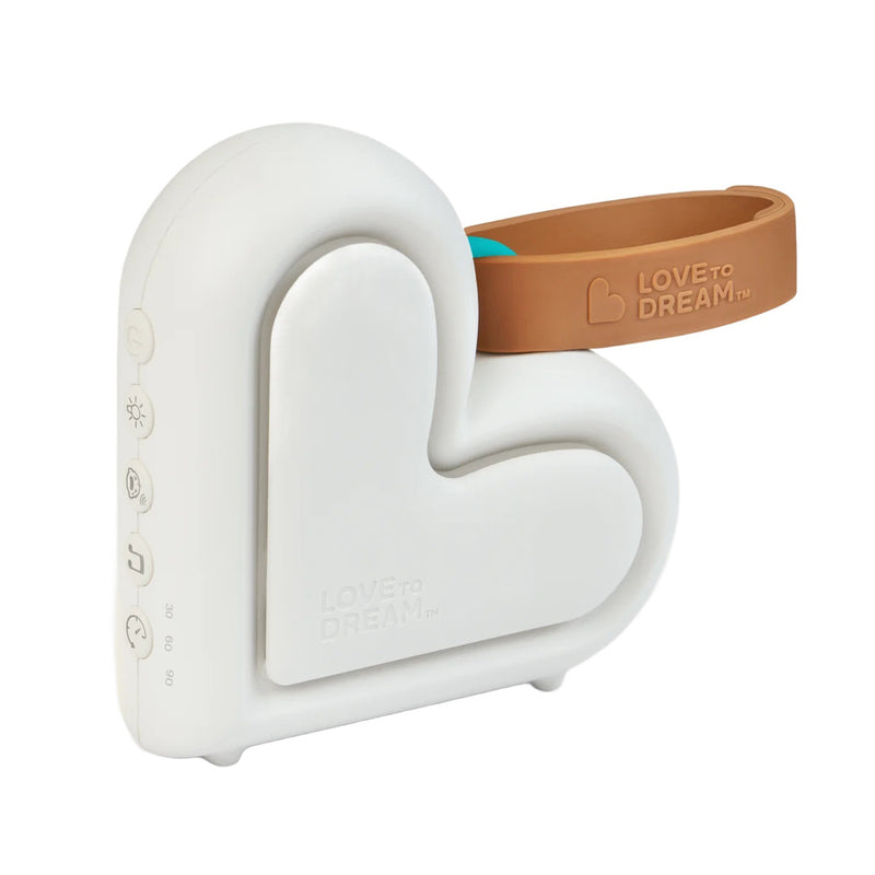 The Love To Dream Sleep Machine by Love To Dream is a white, heart-shaped device with a brown silicone handle, side buttons for controls and volume, and cry detection to help soothe your baby.