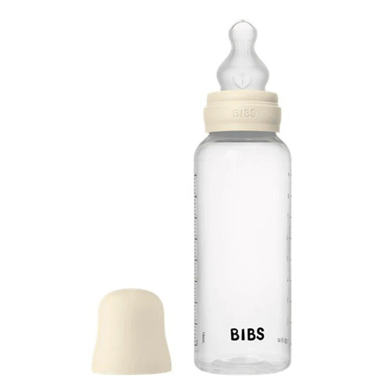 The Bibs Dummies Silicone Baby Bottle 270ml features a cream-colored, breast-like nipple and cap labeled "BIBS." A matching bottle cover sits beside the dishwasher-safe bottle on a white background.