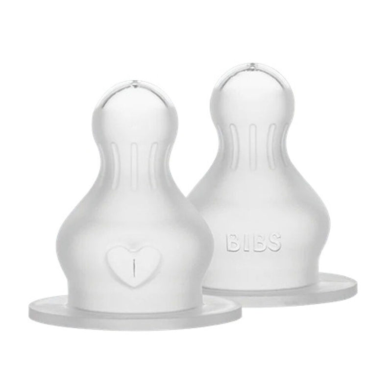 The Bibs Dummies Silicone Baby Bottle Teats 2pk includes two ultra-soft, clear teats with round tops, wide bases, embossed markings, and distinct labels—perfect for transitioning from breastfeeding.