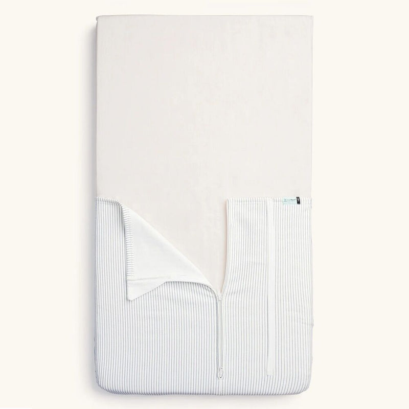 The ErgoPouch Hug Me Cot Blanket 1.0/2.5 Tog in Midnight Stripe, by ErgoPouch, features a cream top and light gray and white vertical stripes—a safer alternative to loose blankets for your baby.