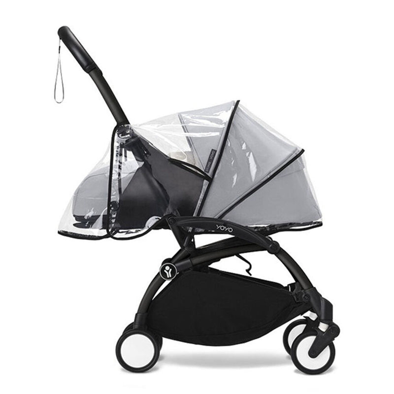 The Stokke Yoyo3 Rain Cover 0+Newborn stroller by Stokke is shown in black from the side, featuring four wheels, an under-seat storage basket, a wrist strap on the handle, and compatibility with a newborn pack for added convenience.