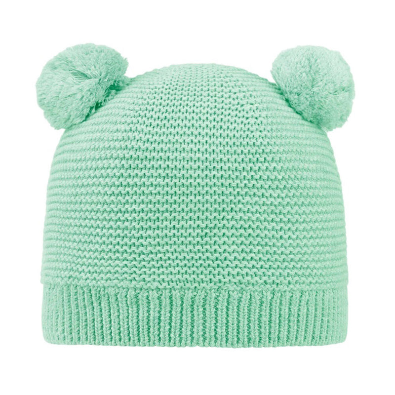 The Toshi Organic Beanie Snowy/Sweet Pea by Toshi is a light green, gender-neutral hat featuring two round pom-poms on top, resembling bear ears.