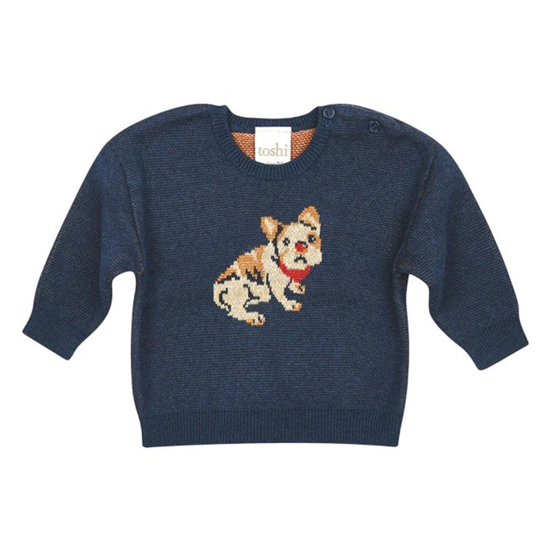 The Toshi Organic Pullover Storytime/Frenchie by Toshi is a navy blue knitted organic cotton baby sweater featuring a cartoon tan and white dog with a red collar on the front.
