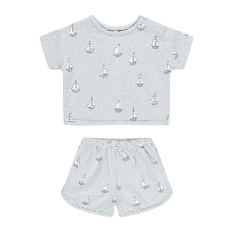 The Quincy Mae Spongey Play Set Sailboats is a light grey organic cotton summer outfit for kids, featuring a short-sleeve shirt and matching shorts with an adorable sailboat print, by Quincy Mae.