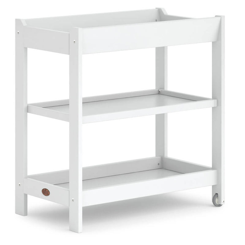 The Boori 3-Tier Changer by Boori is a white wooden baby changing table with a flat top, two open shelves, and a rear wheel for easy movement, offering a simple modern design perfect for any nursery.