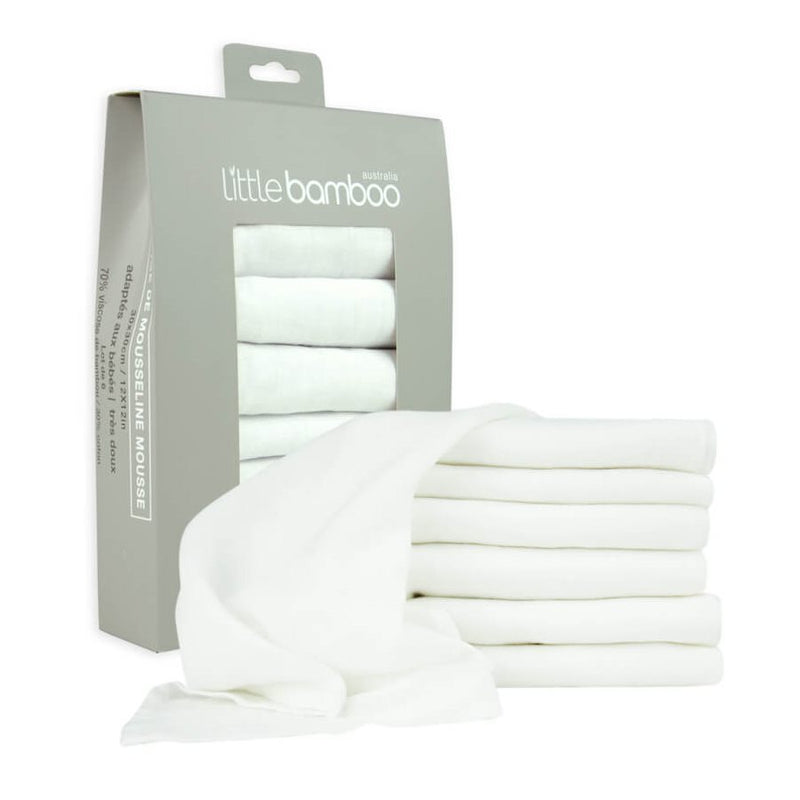 A box labeled "Little Bamboo" holds a 6-pack of Muslin Washers by Little Bamboo, with soft white cloths folded and one draped in front—ideal for gently cleansing your newborn’s delicate skin.