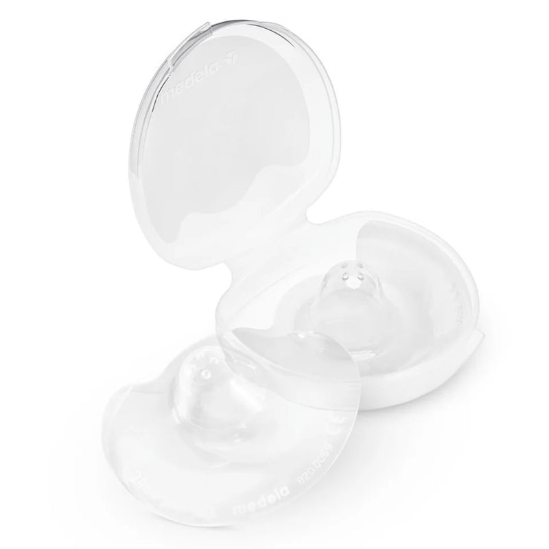 A clear plastic Medela case, partially open, contains two Medela Nipple Shields made of transparent silicone—an essential aid for breastfeeding mothers with sore nipples.