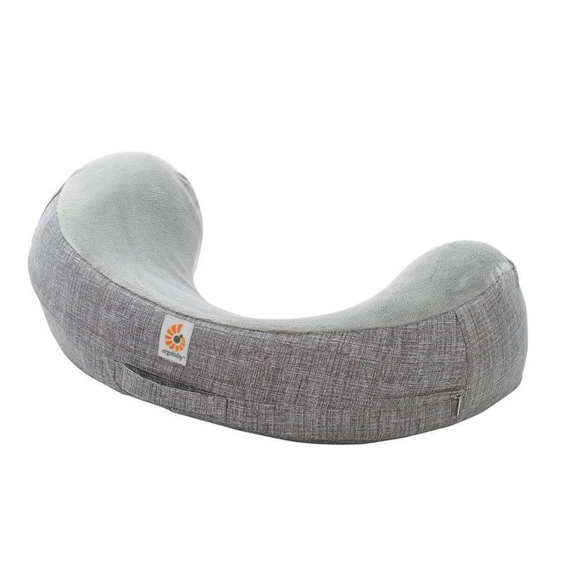 The ErgoBaby Natural Curve Nursing Pillow is a gray, crescent-shaped pillow with a soft, plush patterned cover and ergonomic support. It features the ErgoBaby logo tag on the side.