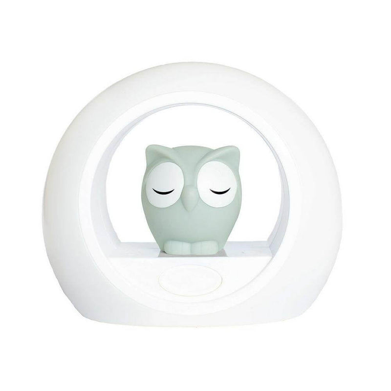 The Zazu Lou Night Light Grey by Zazu features a white circular design with adjustable brightness and a small, light blue-gray sleeping owl figurine nestled in the glowing frame.