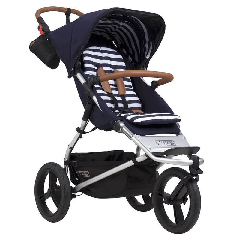 The Mountain Buggy Urban Jungle Luxury Nautical stroller by Mountain Buggy features a modern navy and white stripe design, canopy, hand-stitched leather brown handles, three large wheels, and a storage basket—ideal for a luxury nautical pram experience.