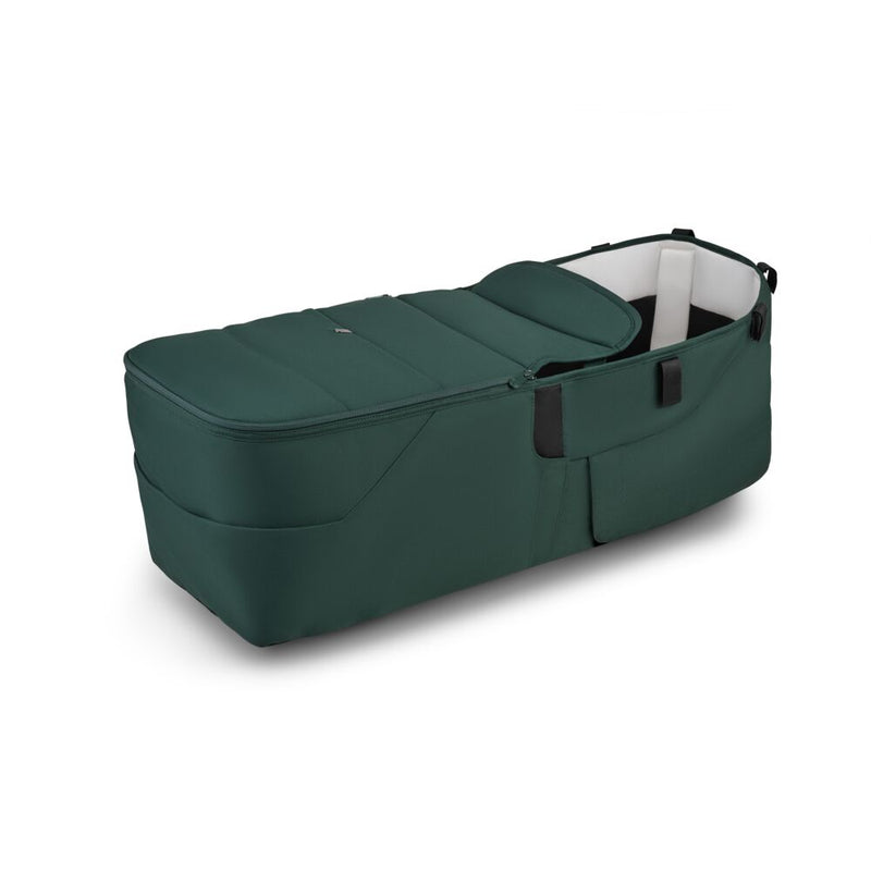 The Bugaboo Donkey 6 Twin Bassinet Fabric Complete by Bugaboo is a dark green portable baby bassinet with black handles, plush fabric, a soft cushioned interior, shown on a white background.