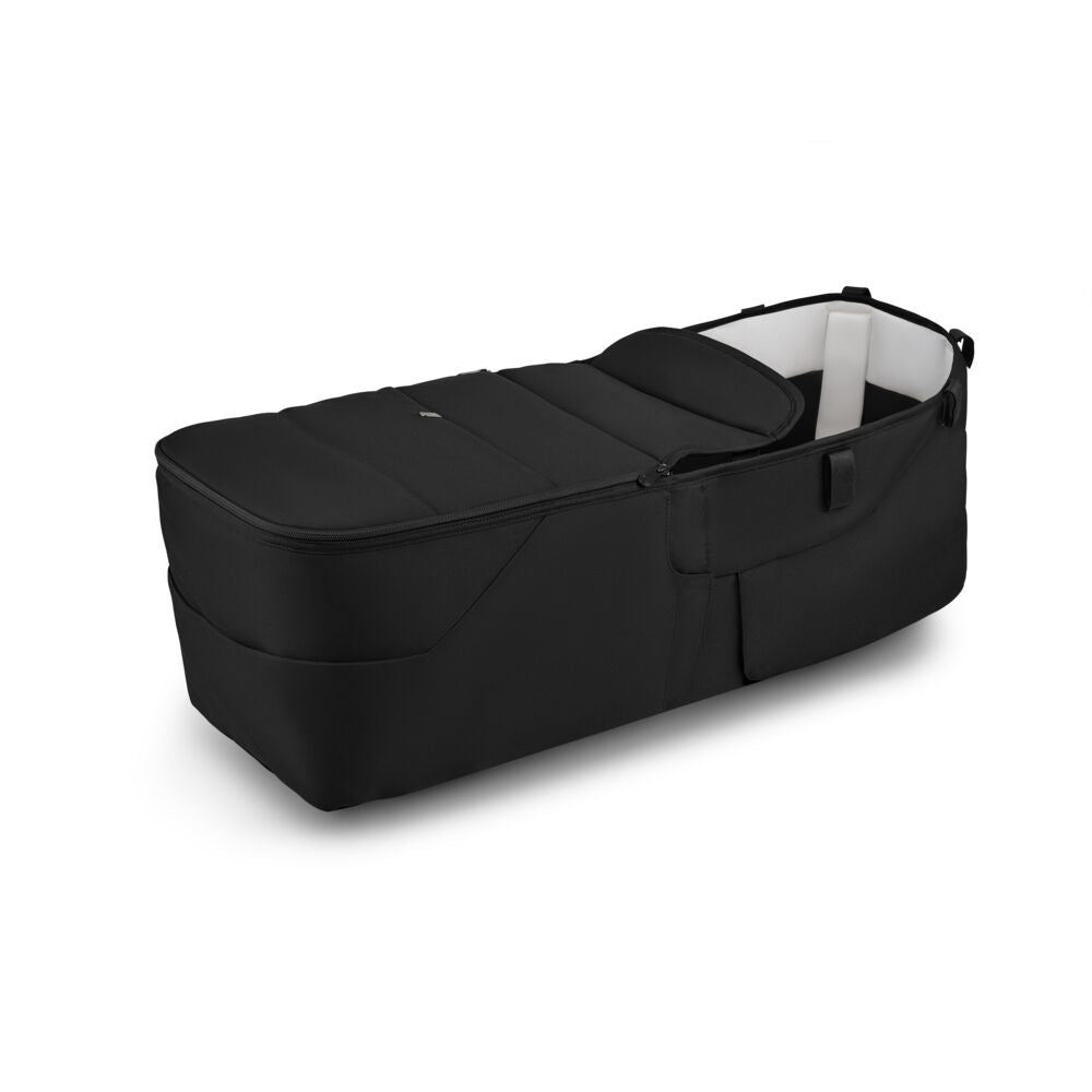 The Bugaboo Donkey 6 twin bassinet fabric complete by Bugaboo is a black, portable bassinet with a soft padded interior, raised sides for comfort and safety, zippered sections, and handles for easy carrying.