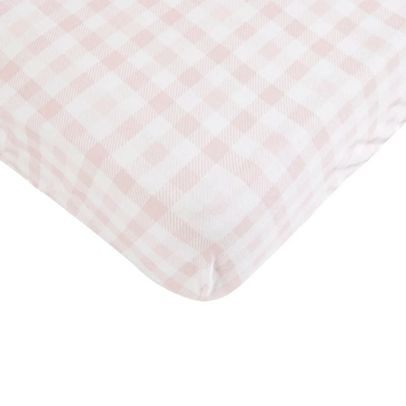 Close-up of the All4Ella Waterproof Fitted Cot Sheet Gingham Pink, featuring a pink and white plaid pattern. The smooth fabric fits tightly over the mattress, making it an essential for any nursery.