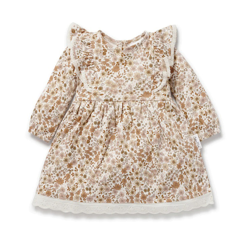 The Aster & Oak Bailey Floral Ruffle Dress features long sleeves, a ruffled collar, soft lace trim, and muted pink-beige tones—crafted from sustainable fabric for a gentle touch on your baby’s skin.