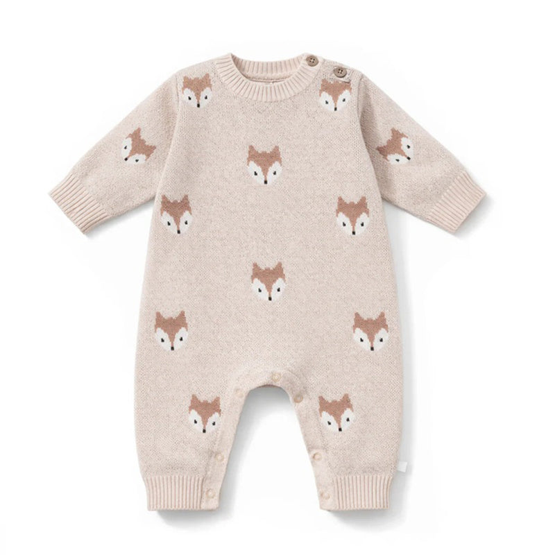 The Aster & Oak Fox Knit Romper in Crystal Grey is a cozy natural cotton romper with long sleeves and legs, featuring brown and white fox faces, plus buttons on one shoulder and the inseam for easy winter changing.