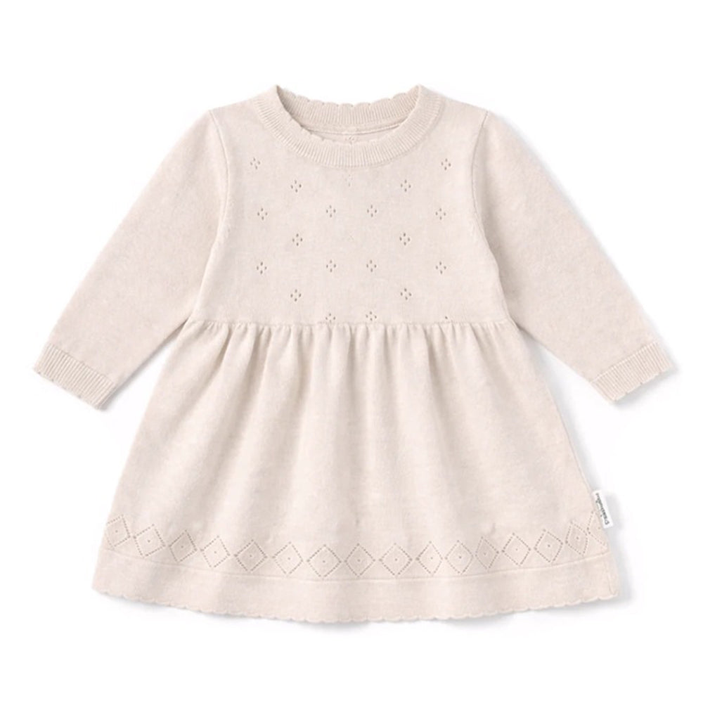 The Aster & Oak Oatmeal Pointelle Knit Dress in Crystal Grey is a long-sleeved, natural cotton baby dress with a textured pattern, delicate eyelet details on the bodice, diamond hem, round neckline, and gathered waist for classic charm.