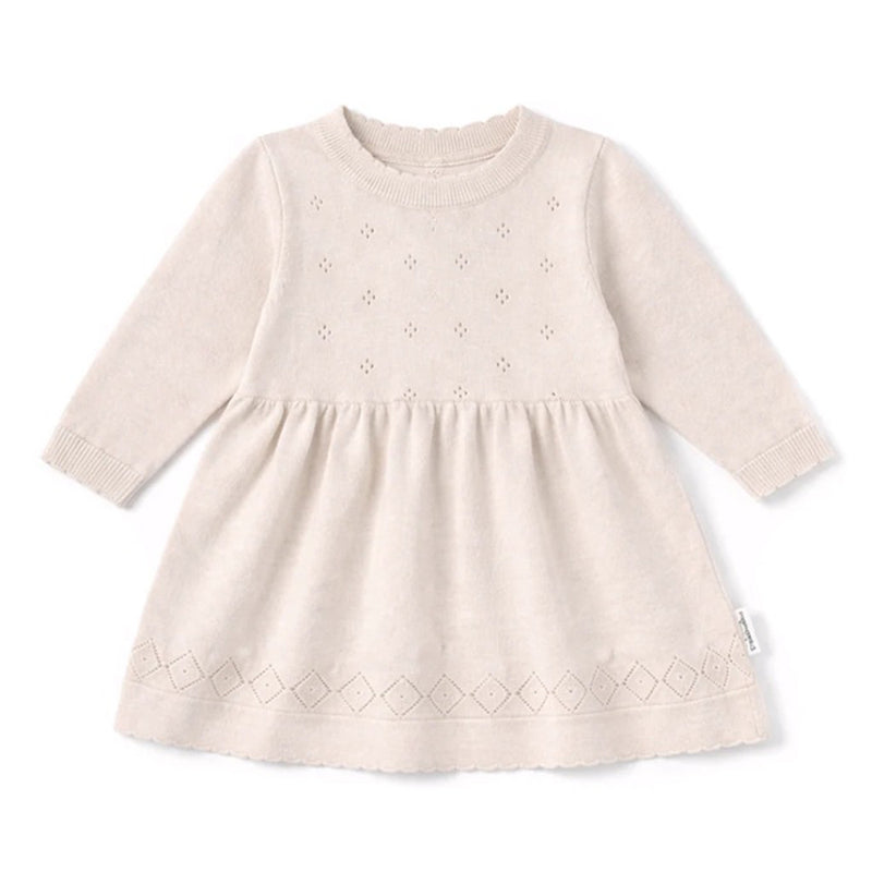 The Aster & Oak Oatmeal Pointelle Knit Dress in Crystal Grey is a long-sleeved, natural cotton baby dress with a textured pattern, delicate eyelet details on the bodice, diamond hem, round neckline, and gathered waist for classic charm.