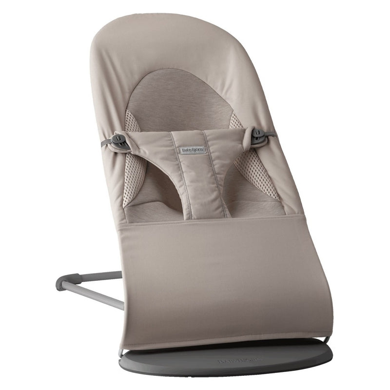 The BabyBjorn Bouncer Balance Soft Woven/Jersey Tri-Fabric is a light beige ergonomic baby bouncer with a soft seat, safety harness, sturdy metal frame, and minimalist design that provides natural rocking for infants.