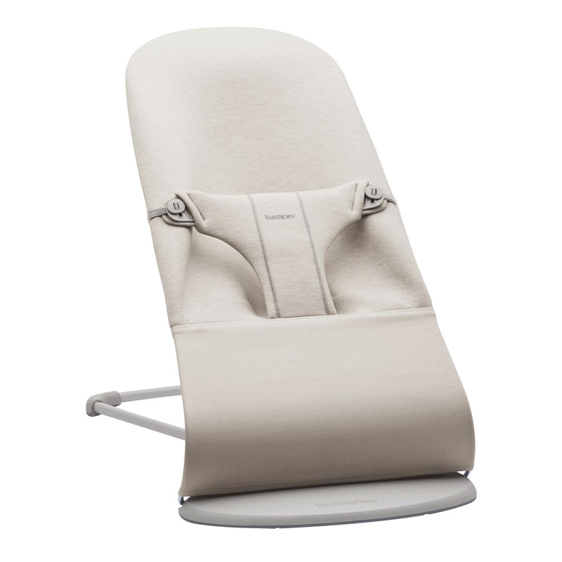 The BabyBjorn Bouncer Bliss 3D Jersey in beige offers a minimalist look with a soft fabric seat, secure harness, and curved metal base for gentle rocking.