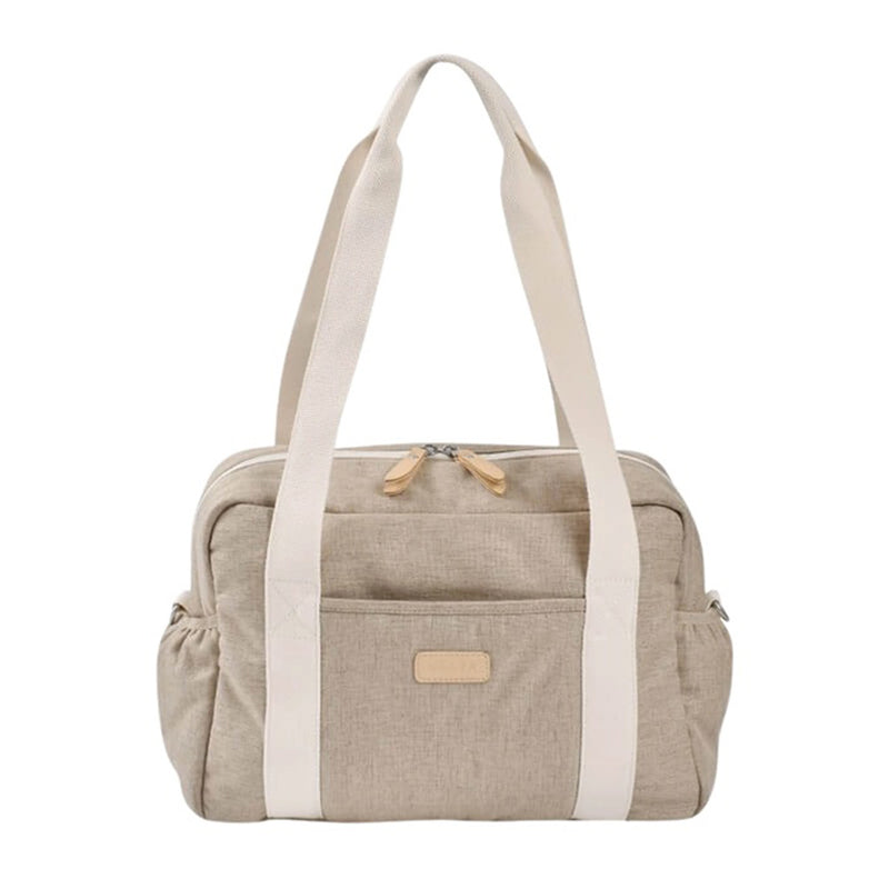 The Beaba Paris Nappy Bag by Beaba is a beige fabric tote with cream handles and trim, a front patch, zippered main section, side pockets, and pram attachment—a practical unisex changing bag inspired by Parisian style.