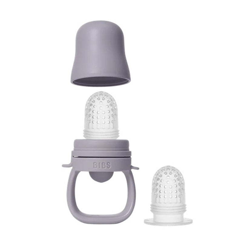 The Bibs Dummies Baby Feeder by Bibs Dummies features a purple silicone handle, clear teat for teething relief, a matching cap, and an extra teat—ideal for weaning little ones.