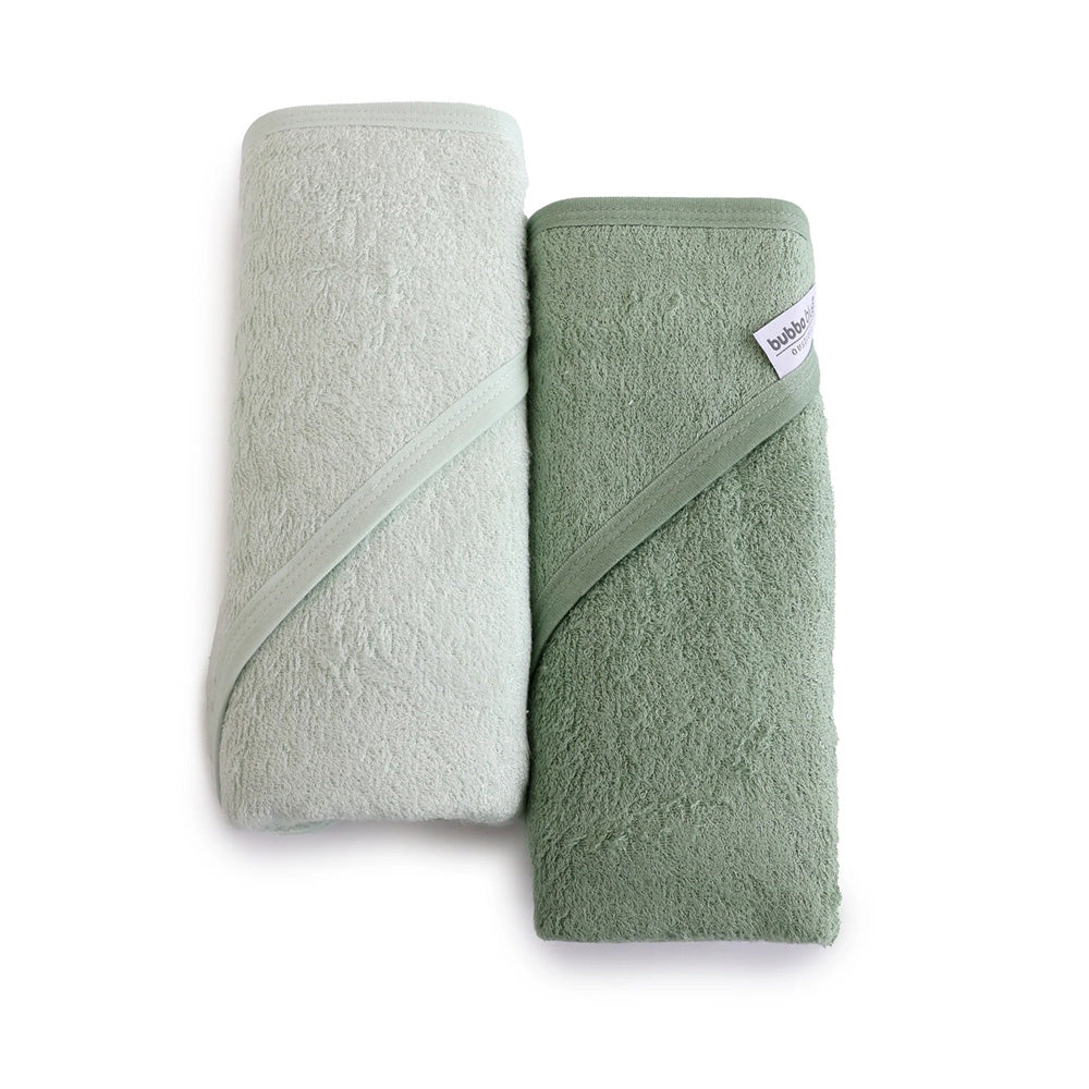 Two Bubba Blue Bubba Sundae 2PK Hooded Towels, rolled up in light and dark sage green, are placed side by side on a white background. One bamboo towel shows a visible fabric tag.