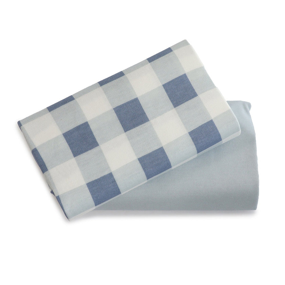 Two Bubba Blue Bubba Sundae 2PK Jersey Bedside Sleeper Fitted Sheets—one blue and white checkered, one solid light blue—are shown on a white background. Perfect for nursery bedding.