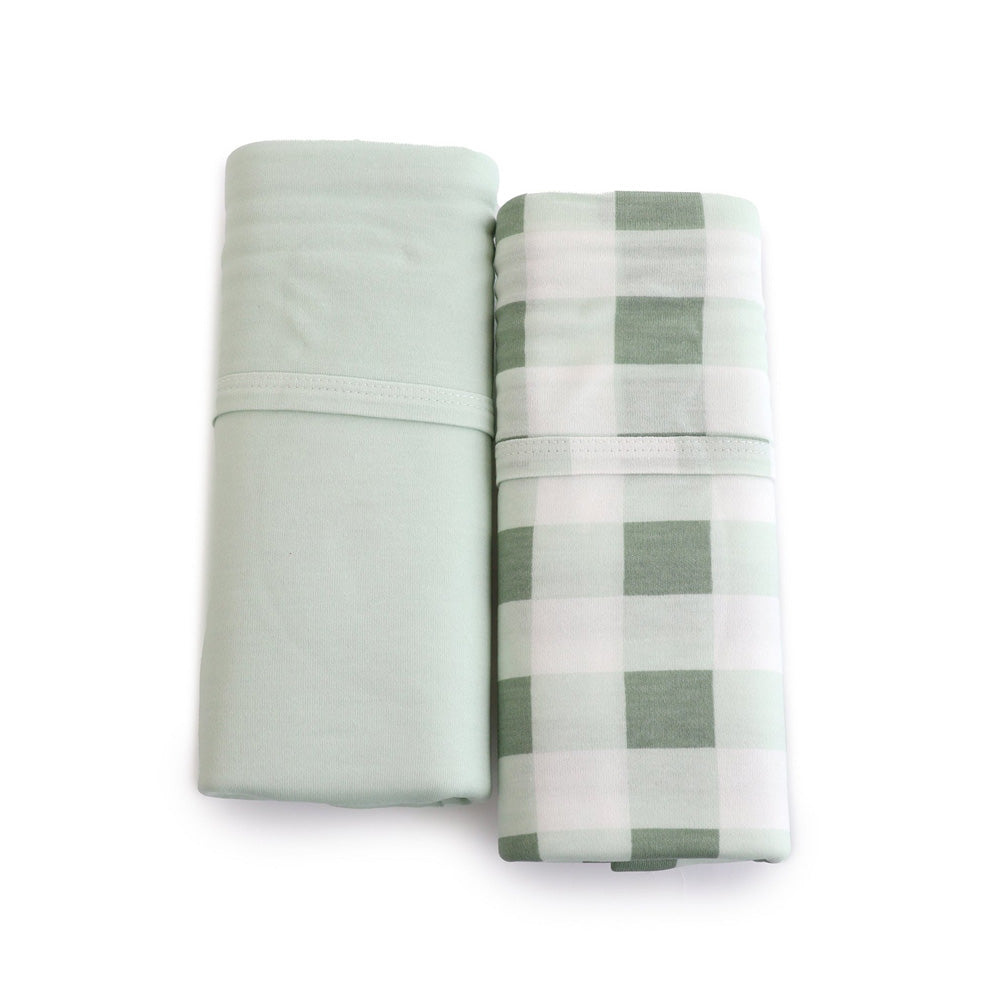 The Bubba Blue Bubba Sundae 2PK Jersey Swaddle Wraps, featuring one solid light green and one light green and white checkered wrap, are displayed side by side on a white background for a serene nursery touch.