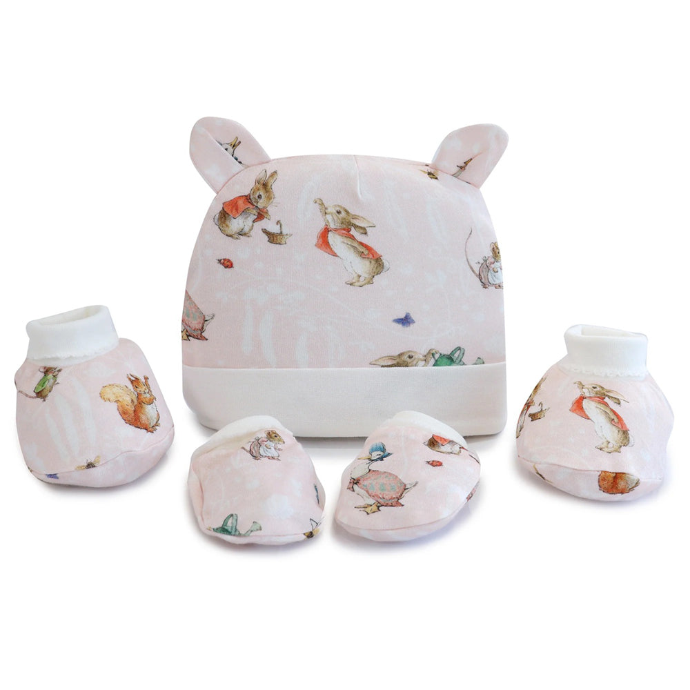 The Bubba Blue Flopsy Mopsy & Cottontail 3PCS Layette Set includes a pastel pink beanie with bear ears, booties, and mittens, featuring adorable rabbits and squirrels—an ideal newborn or baby shower gift from Bubba Blue.