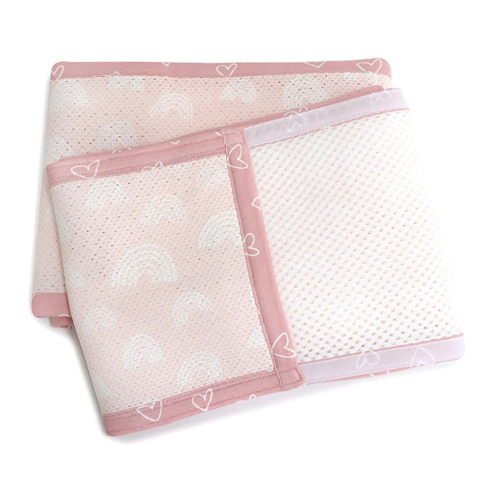 The Bubba Blue Nordic Cot Liner/Bumpers by Bubba Blue, in pink and white bamboo cotton mesh with rainbow and heart designs, is neatly folded on a white background.