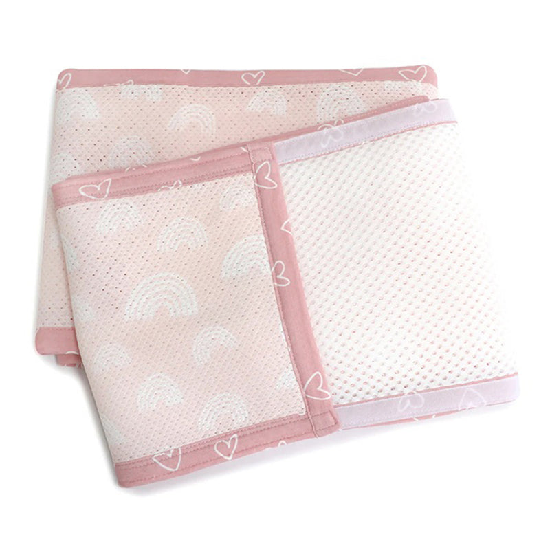 The Bubba Blue Nordic Cot Liner/Bumpers by Bubba Blue, in pink and white bamboo cotton mesh with rainbow and heart designs, is neatly folded on a white background.