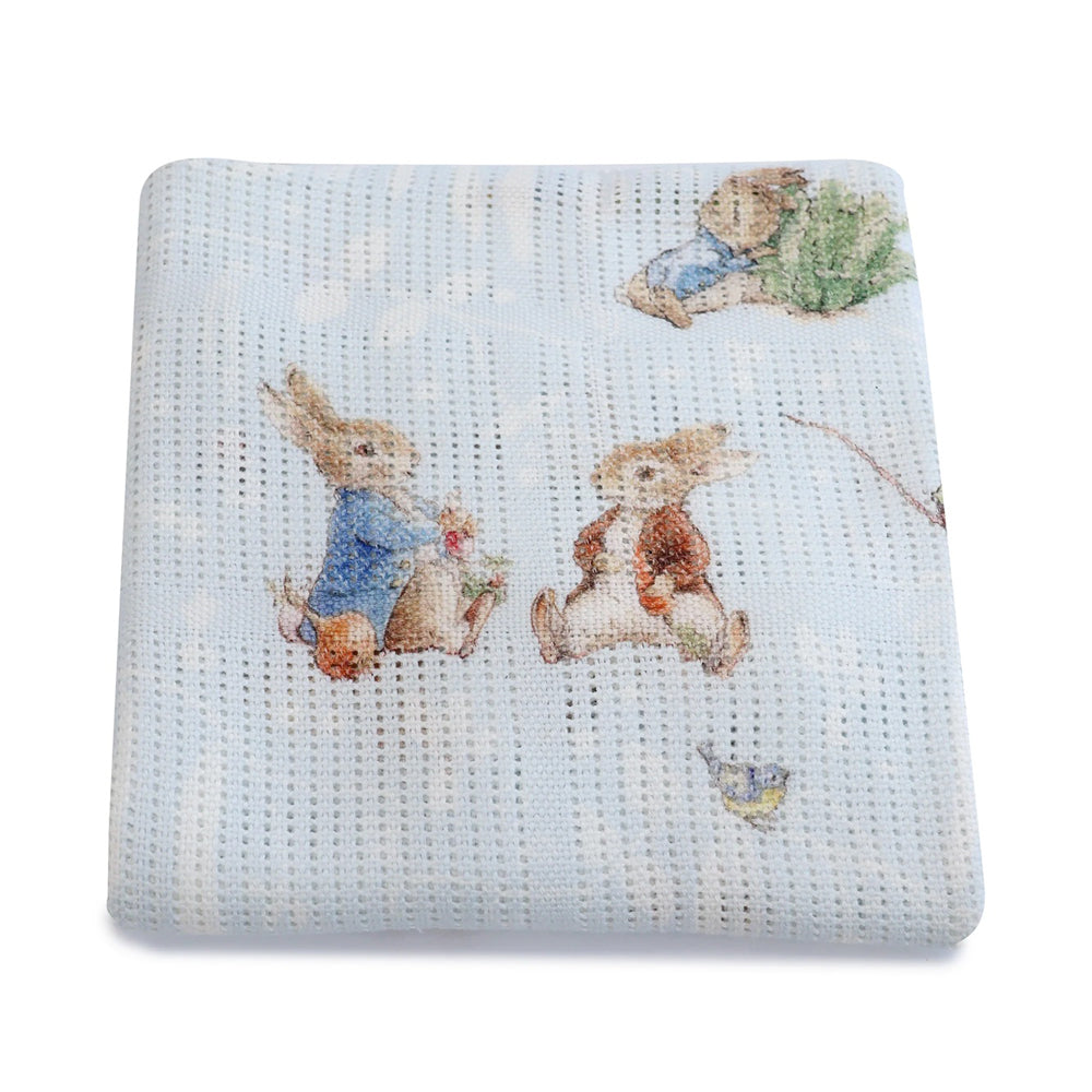 The Bubba Blue Peter Rabbit & Benjamin Bunny Digital Print Cellular Blanket is a light blue bamboo cotton baby blanket featuring rabbits in clothing, charming grass, and a bird, inspired by Beatrix Potter.