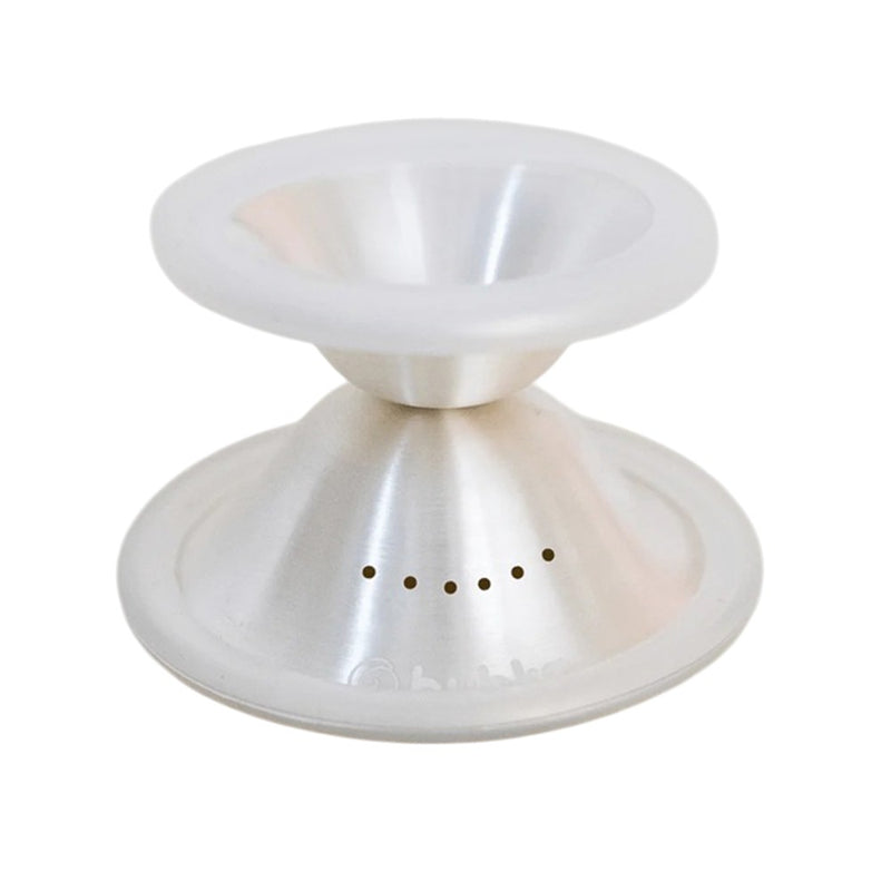 The Bubka Aeroflow Silver Nipple Shields by Bubka are silver and white, conical metal accessories with a wide rim and small ventilation holes, designed for breastfeeding relief in a modern, minimalistic style.