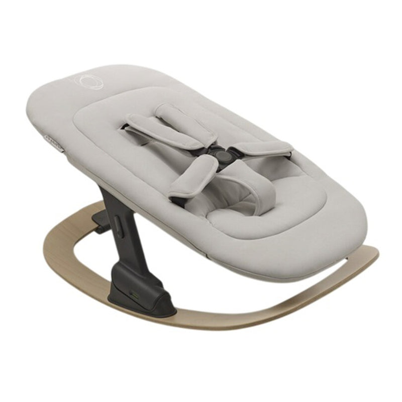 The Bugaboo Giraffe Baby Rocker Complete V26 by Bugaboo features a modern ergonomic design with a light grey cushioned seat, safety harness, and natural wood curved base for gentle rocking.