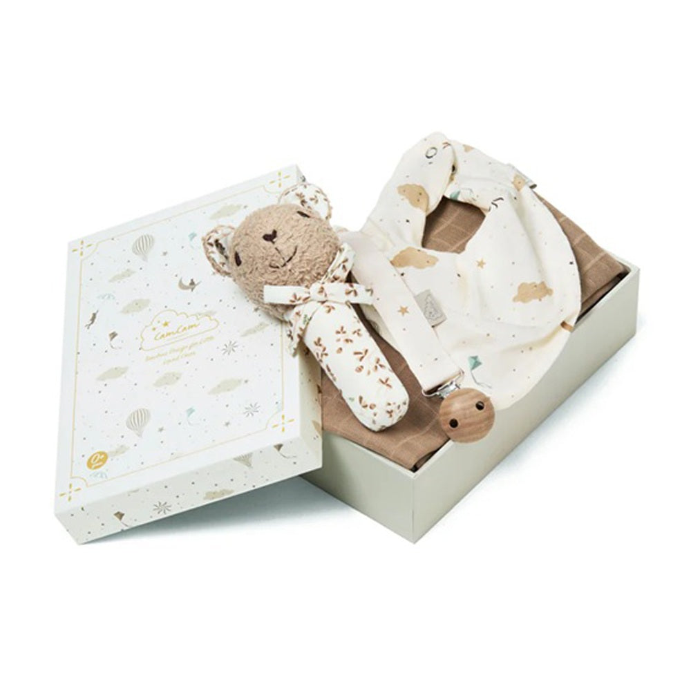 The Cam Cam Copenhagen Baby Essentials Gift Box features a soft beige teddy bear rattle and a cream baby bib with cloud and star patterns, beautifully presented on a white background.