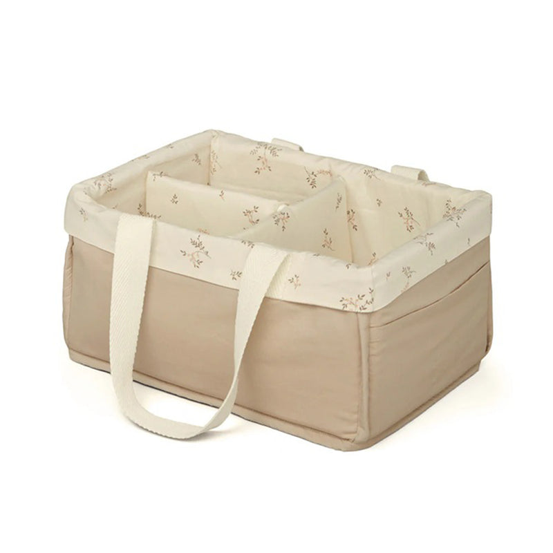 The Cam Cam Copenhagen Changing Caddy is a rectangular beige fabric organizer with white handles, a cream floral interior, and soft padded sides—ideal for stylish nursery storage and organization.