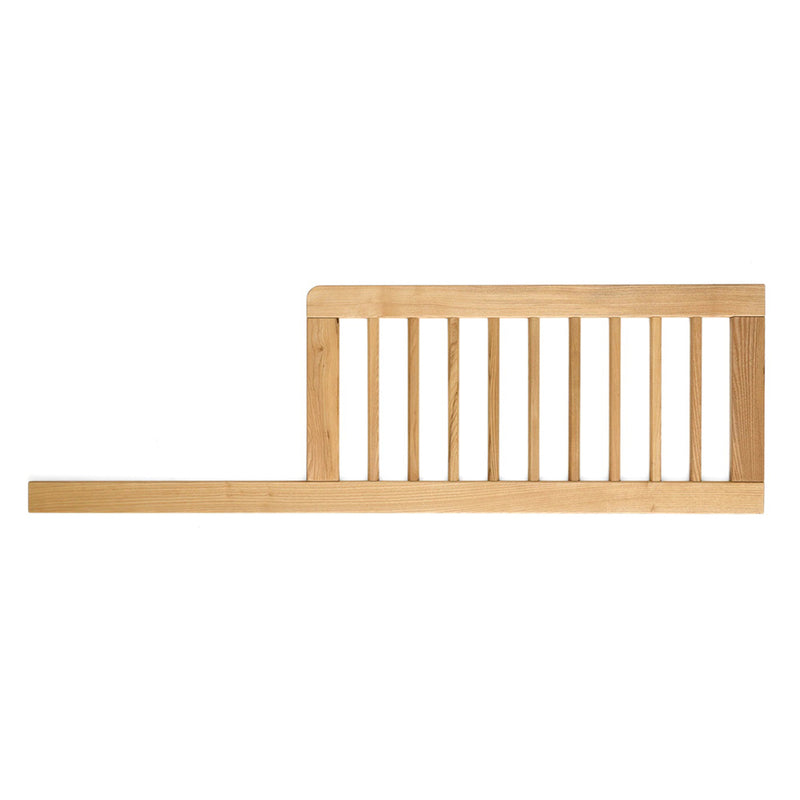 The Cariboo Mackenzie Toddler Bed Conversion is a wooden ash timber rail with vertical slats and a natural finish, designed to keep children safe in bed. It features a stable horizontal base and is part of the Cariboo brand conversion kit.