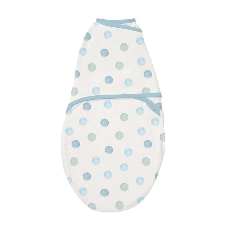 The Clevamama ClevaSleep Swaddle Blue Spot by Clevamama is a soft, breathable white Australian Cotton swaddle with light blue trim and watercolor-style blue and gray polka dots, perfect for newborns and shown on a white background.