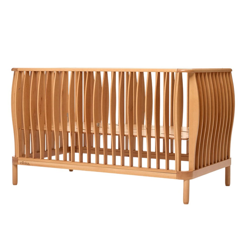 The ErgoPouch Ellska SKYE Cot features curved slats, a natural beechwood finish, an open frame, four sturdy legs, and a minimalist modern design. It easily converts into a stylish toddler bed.