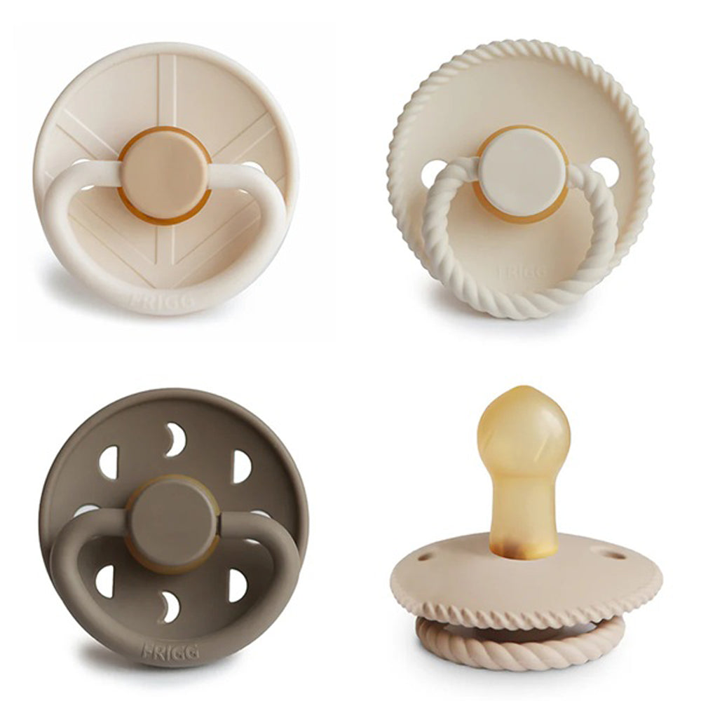 Four FRIGG 4 pack Latex Crystal Sparkle pacifiers are displayed in a grid, each with distinct designs: two have rope-like edges, one is solid beige, and one is brown with holes. All feature round handles or nipple tips.