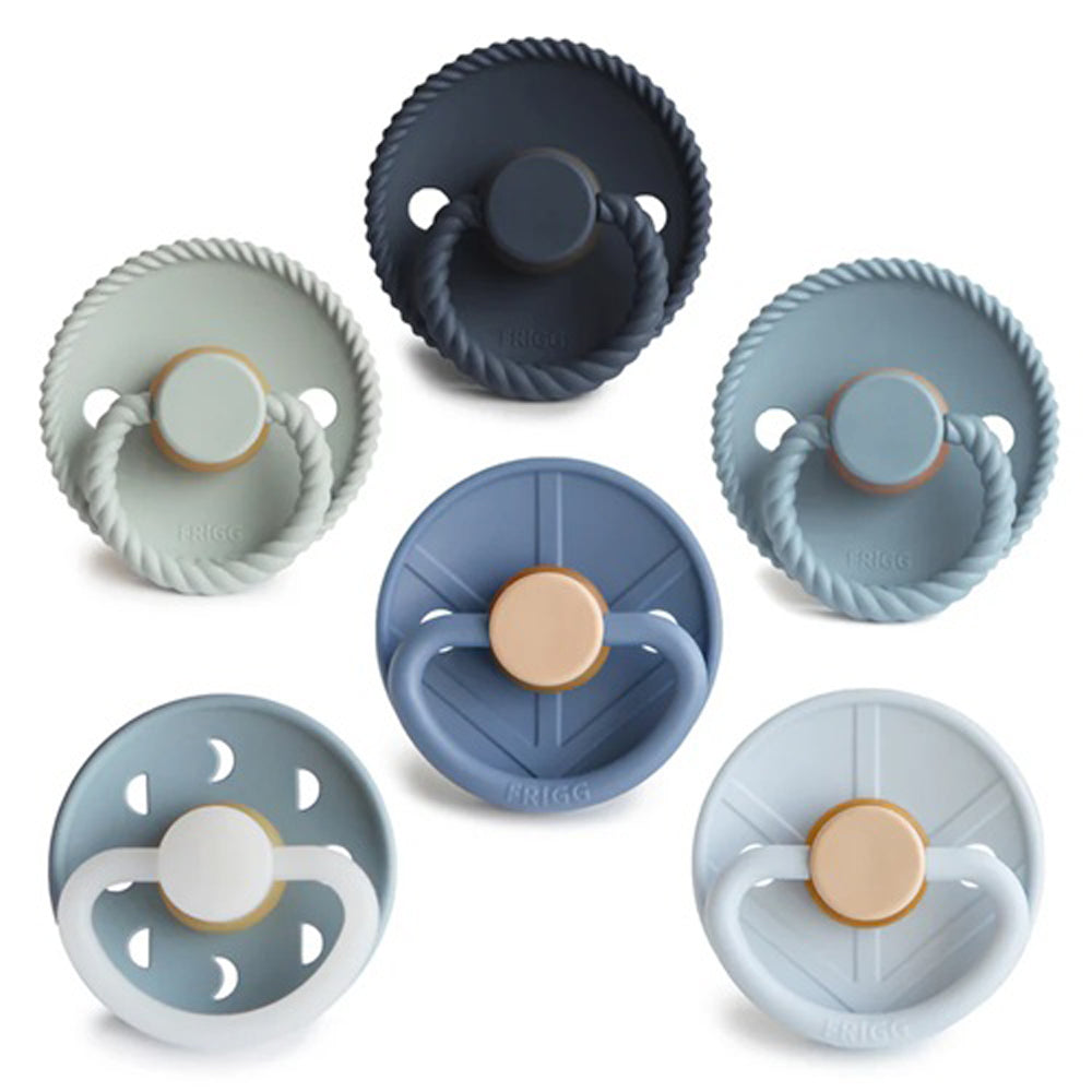 The Frigg 6 pack Latex Endless Sea by Frigg features six Danish-made pacifiers in blue and gray tones, each with a round shield and unique designs, displayed in two rows on a white background.