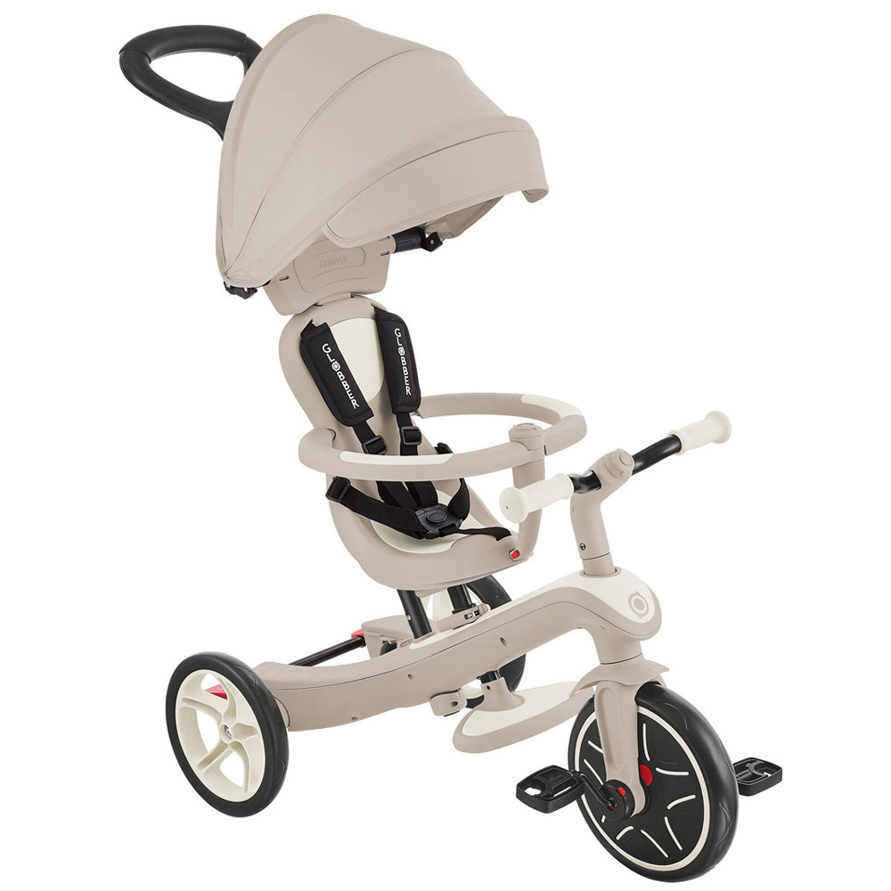 The Globber Explorer Trike 4 in 1 - Ecologic by Globber is a beige, eco-friendly adjustable tricycle with a canopy, safety harness, handlebar, footrests, three wheels, and an adult push handle for assisted steering.