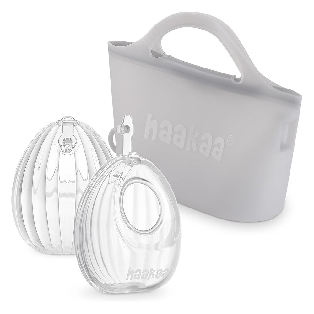 The Haakaa Wearable Manual Breast Pump with Steriliser Bag 75ml 2pk features clear, rounded silicone collectors and a semi-transparent gray carrying case with handle and "haakaa" logo—compatible with any silicone breast pump.