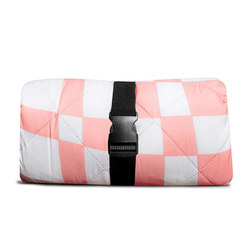 The IZIMINI Isla Picnic Rug by IZIMINI is a folded, water-resistant mat featuring a pink and white checkered pattern, secured with a black strap and plastic buckle.