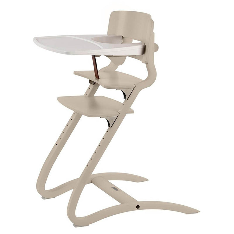 The Leander Louie Chair Bundle by Leander is a modern beige highchair for infants and toddlers, featuring an adjustable seat, footrest, detachable white tray, and ergonomic design with curved legs for stylish dining comfort.