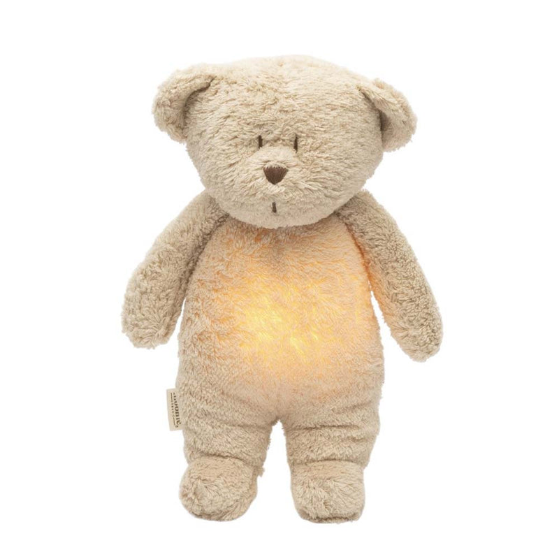 The Moonie Organic Humming Bear Sand by Moonie is a soft, beige plush toy that stands upright with a glowing night light in its belly—featuring round ears, small eyes, and a stitched nose and mouth—making it the perfect sleep aid for babies.